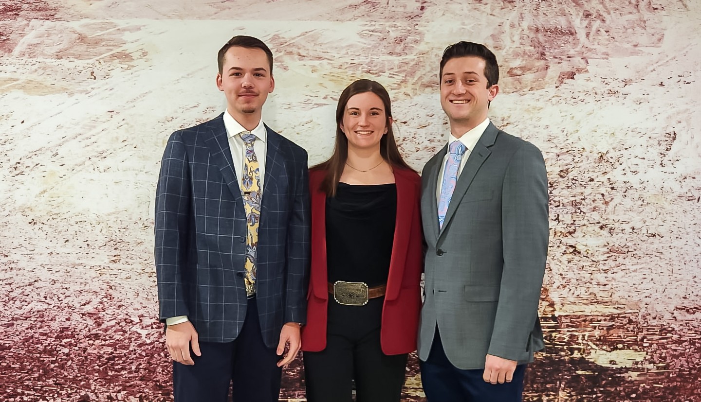 a woman and two men stand together