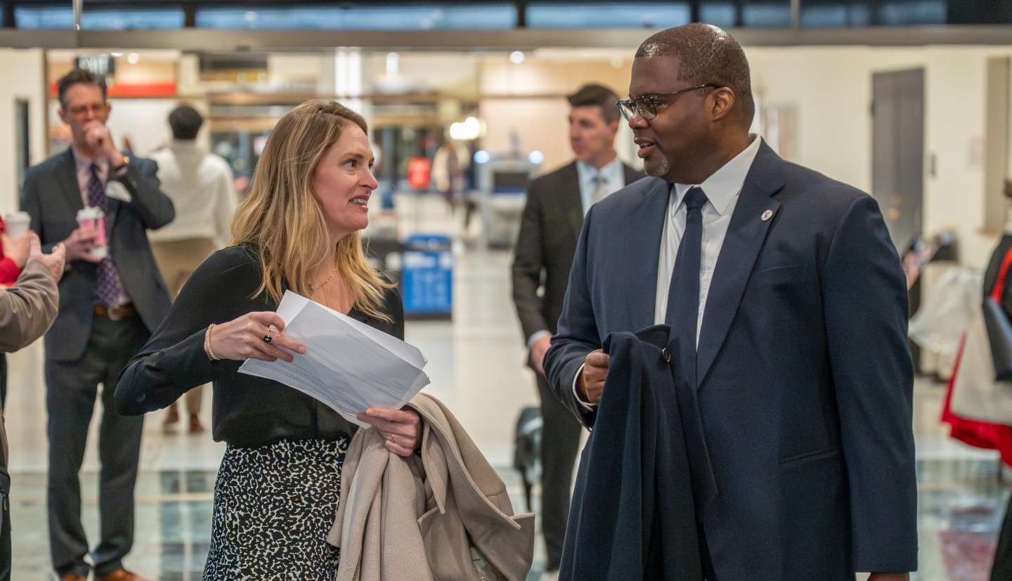 Kwesi in formal attire discussing urban agriculture with a colleague