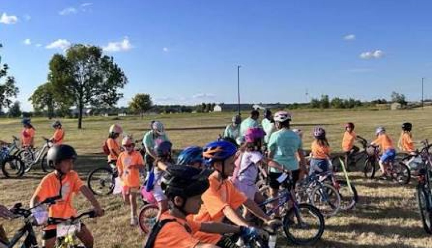 children with bike helmets on bicycles at an adventure team event