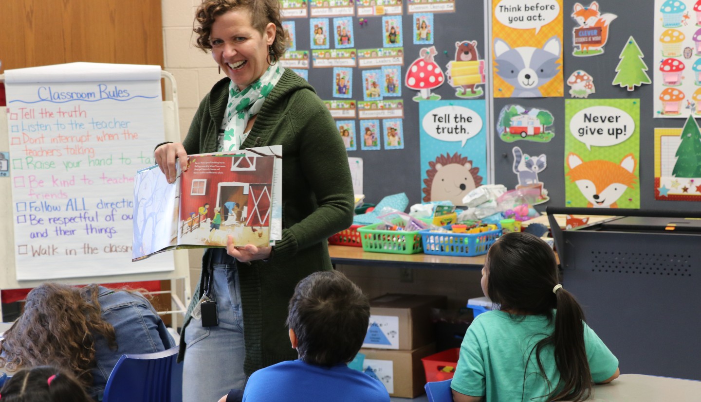 Melanie Forstrom reading a book to children