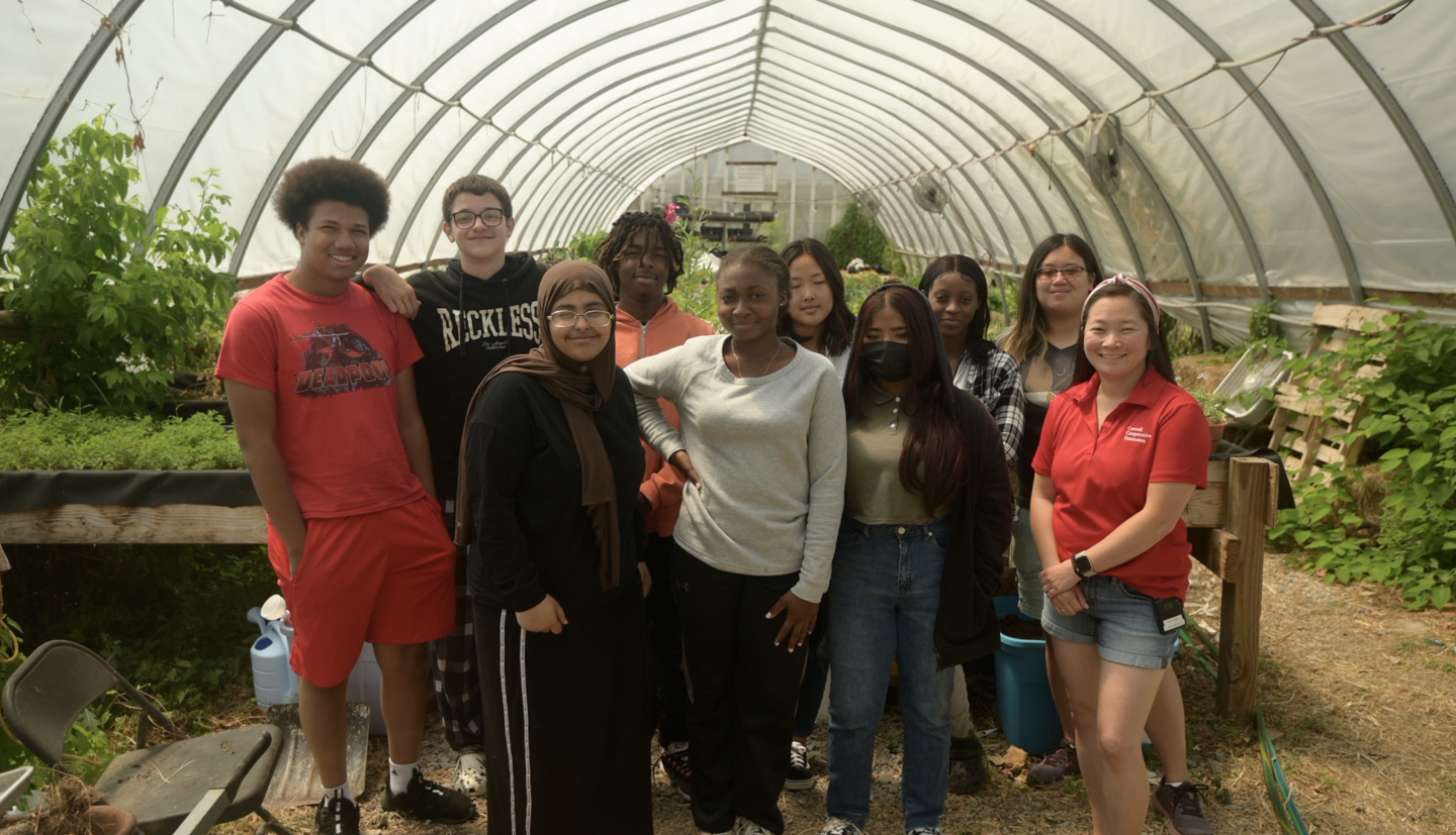 Mallory Hohl and a group of participants standing in a greenhouse.