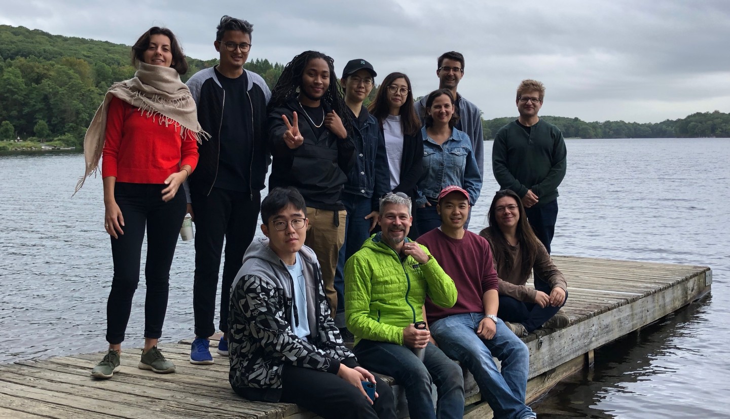 group of people on a dock on the Hudson River pose for a photo