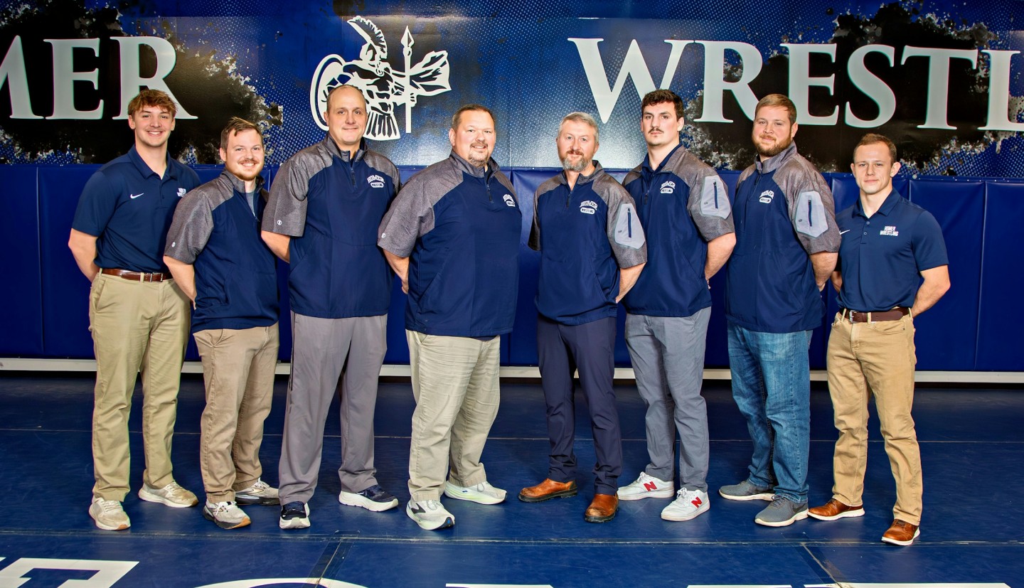 Coaches pose together.