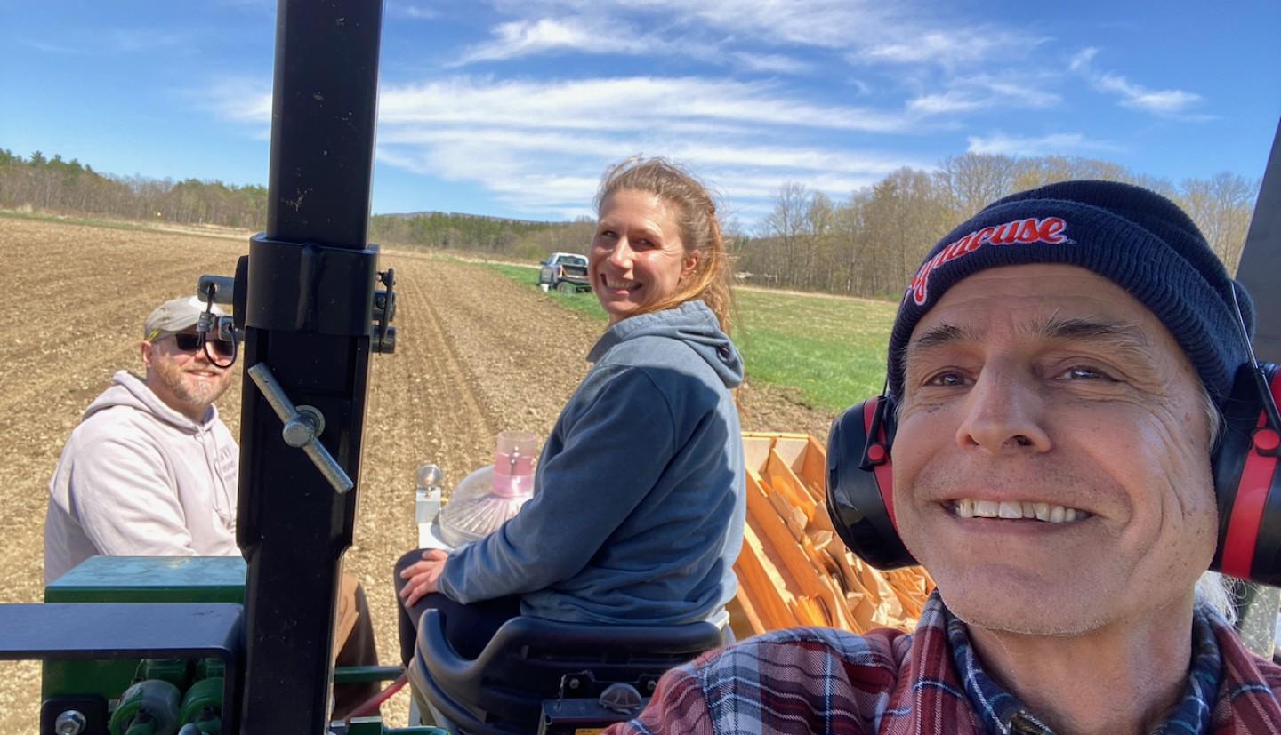 A field crew driving a seeder in a field