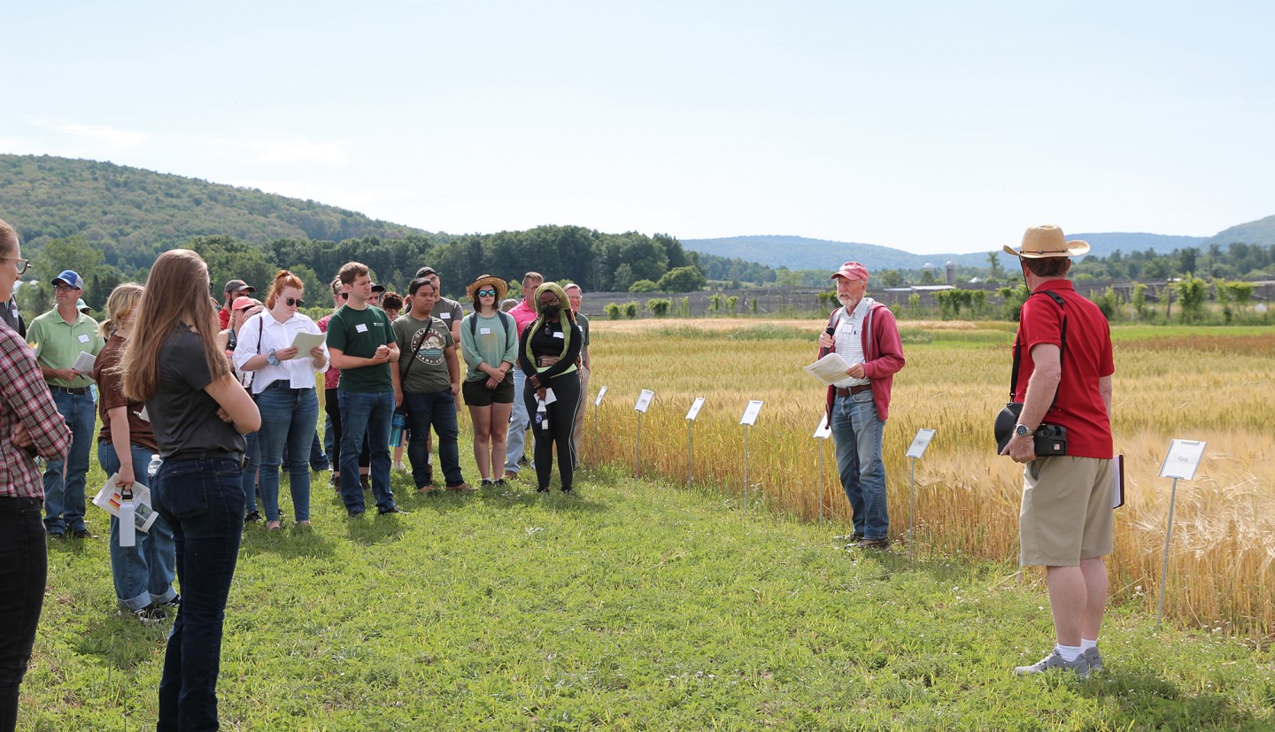 a large group of people next to small grain plots