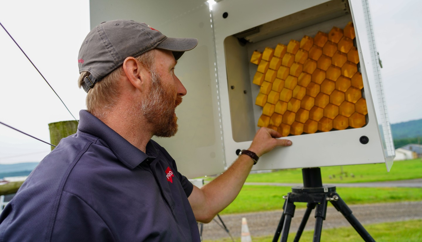 a man looks at a cluster of golden mirrors inside a sensor