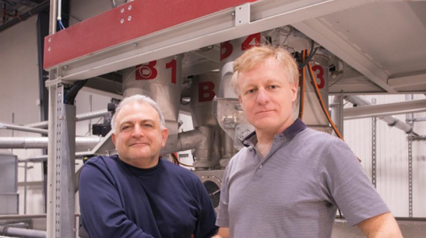 white men stand in front of manufacturing hardware