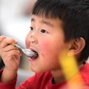 Child eats ice cream with a spoon