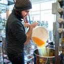 Collin Dillingham pouring apple juice into a fermentation tank