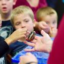 Children observe a cockroach held by a volunteer