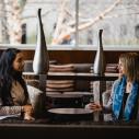 Two women sitting down and speaking to one another