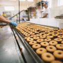 A person working in a donut food production line