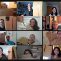 Male and female students sitting on a Zoom call holding up cardboard boxes 