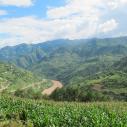Green mountain landscape with a valley and river on a sunny day