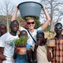 A student standing with five children outside in Africa 