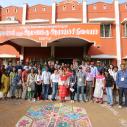 A group of students and professors stand in front of university in India