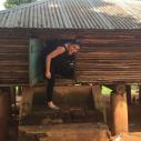 A woman stands in a wooden shack used to store grain