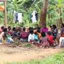 A group sits outside near a tree