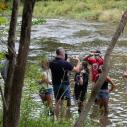 Instructor Marc Goebel and students standing outside in a river while talking