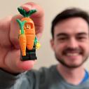 A man holds a carrot LEGO figurine