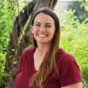 Headshot of Carly Bass smiling in front of a tree