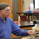 a man picks raw wool in a lab classroom