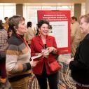 Three women gather in a semi-circle at an event