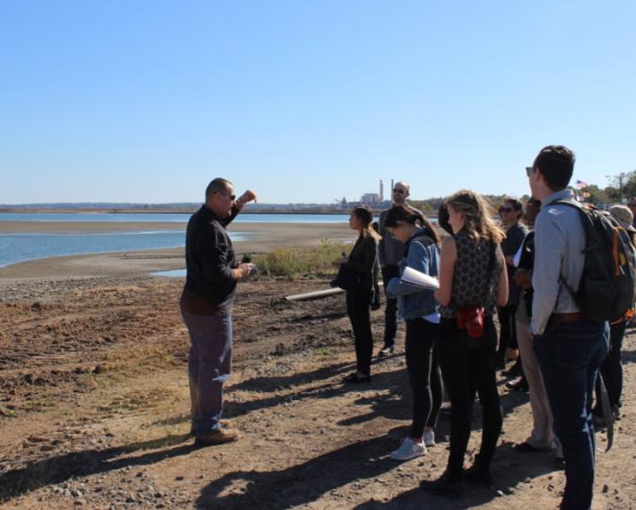 students and professor on river bank
