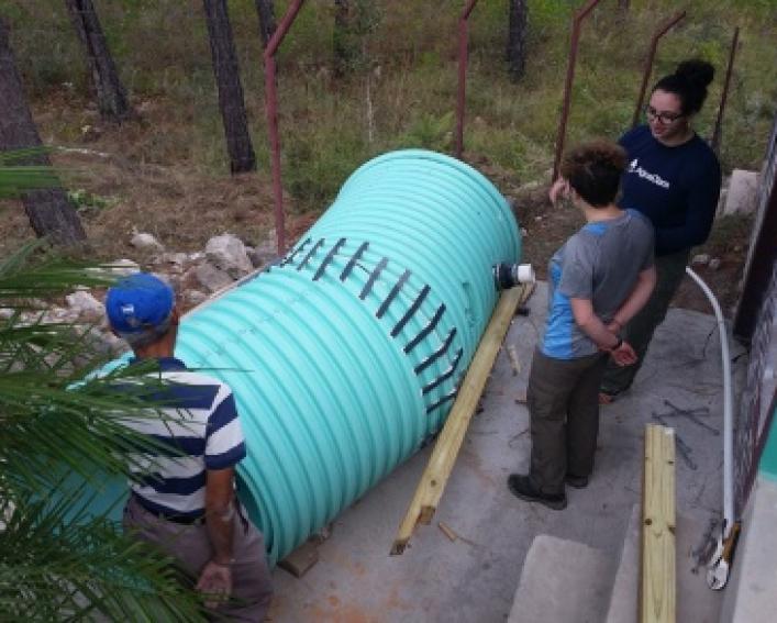 Zoe Maisel and Erica Marroquin install water purification system with Jorge Dueñas Carcamo