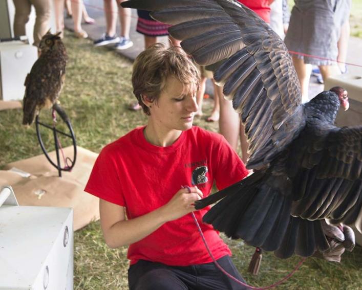 A female student holds a large raptor