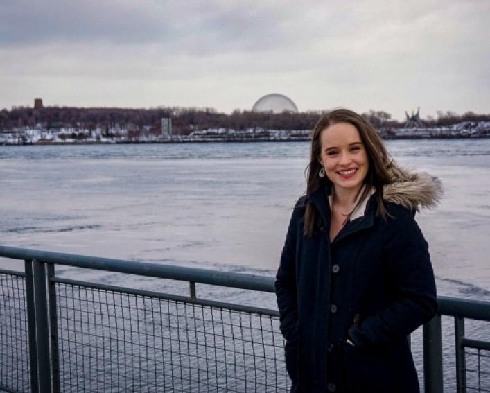 Alumni, Caitlin Anderson, standing in front of an icy river.