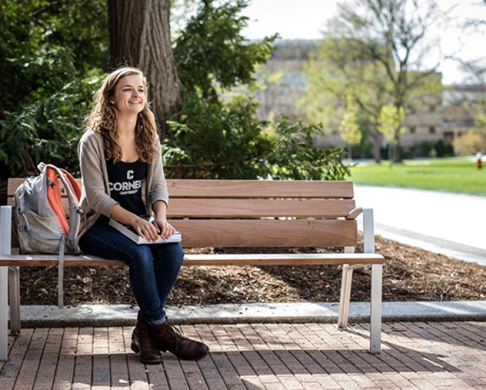 Plant sciences alum Hannah Fuller sits on bench outside Plant Science Building