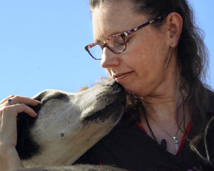 A woman and a dog touch noses