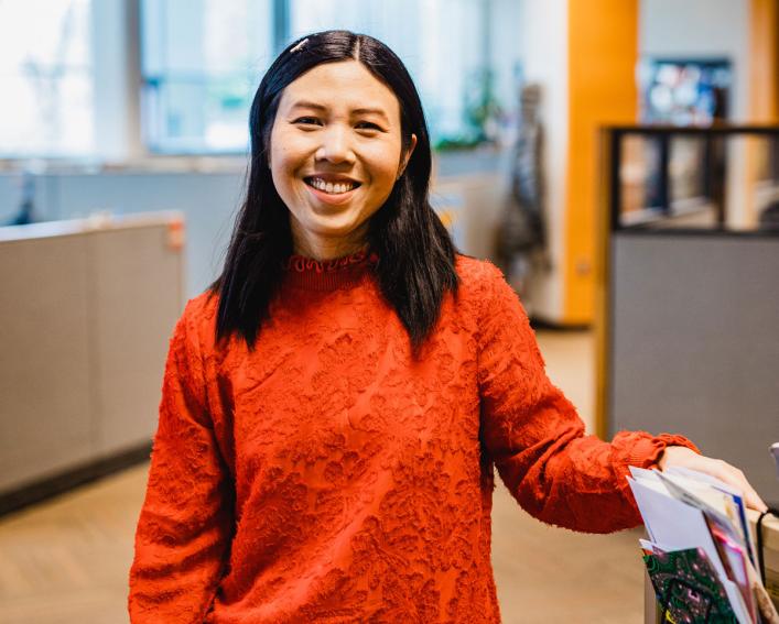 Woman smiling near bookcase 