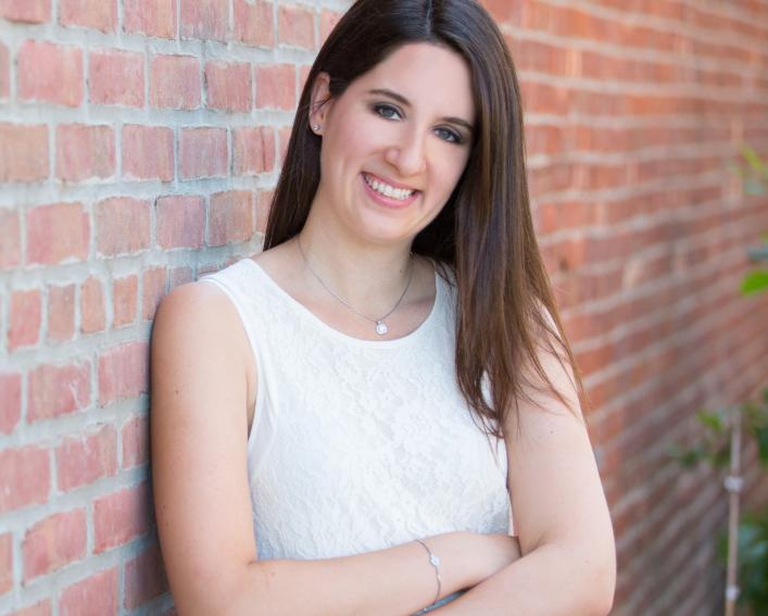 Dr. Marisa Cohen leans against a brick wall