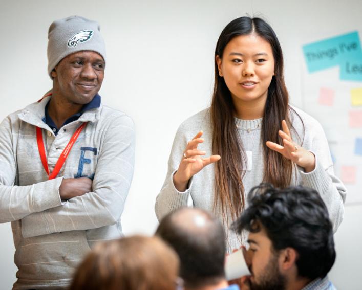 A male and female speak to a room full of people, Things I've learned this fall on a poster in the background