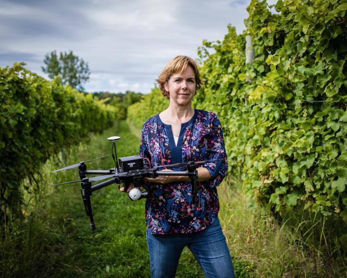 Justine Vanden Heuvel holding drone in vinyard