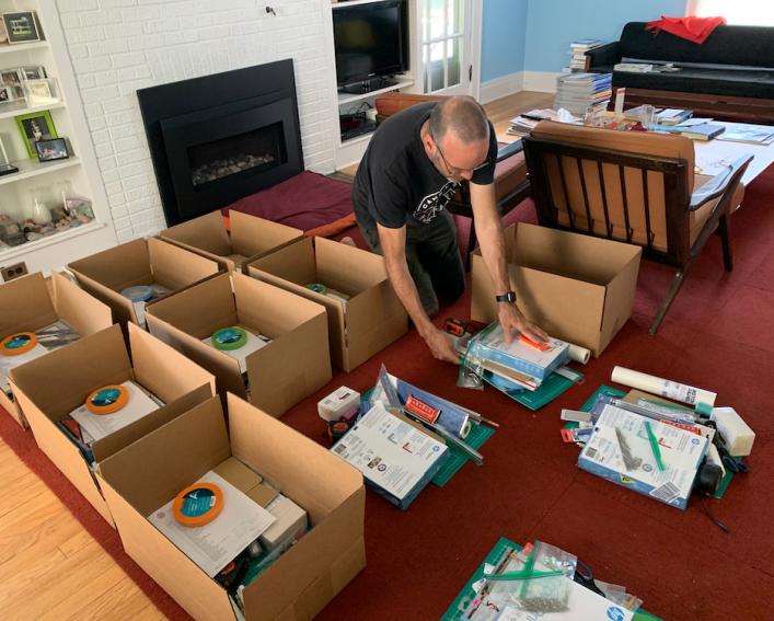 Martin sitting on the floor assembling boxes in his living room.
