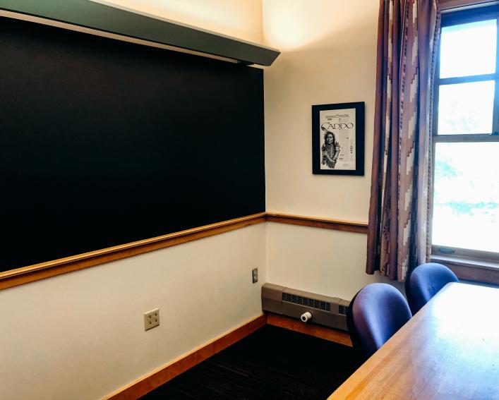 One of the Akwe:kon study rooms with a table, chairs and blackboard.