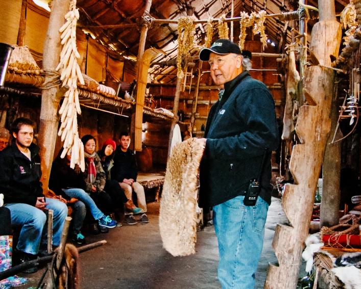 Akwe:kon residents engage in a tour of a reconstructed Longhouse at Ganondagan.