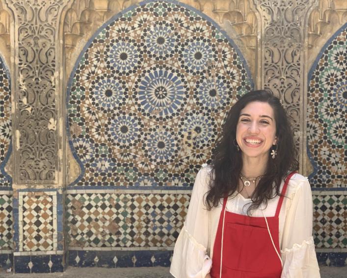 Woman stands against tile wall 