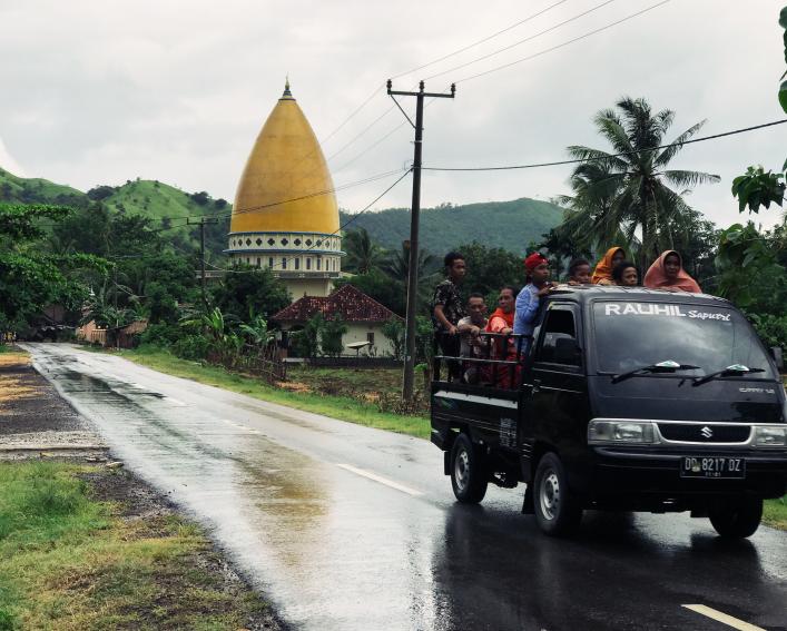 Group rides in the bed of a pick up truck in rural Indonesia