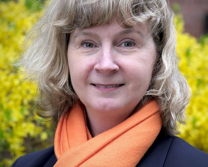 shari romar with peach scarf and forsythias flowering in the background