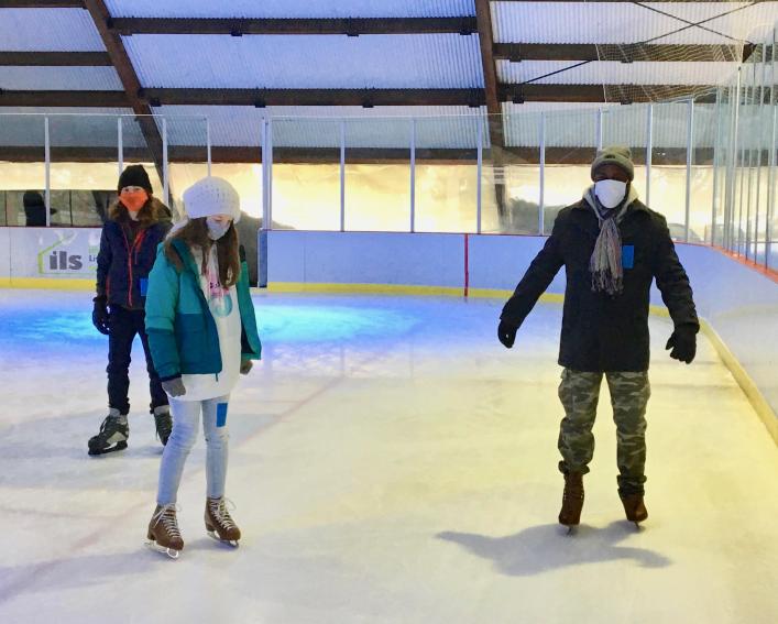 People go iceskating at a rink