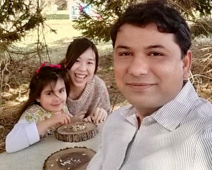 Family of three poses for a photo