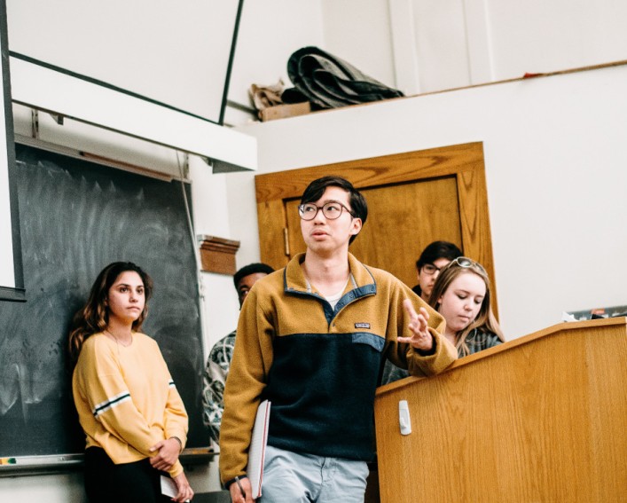 Student presenting at a podium. 