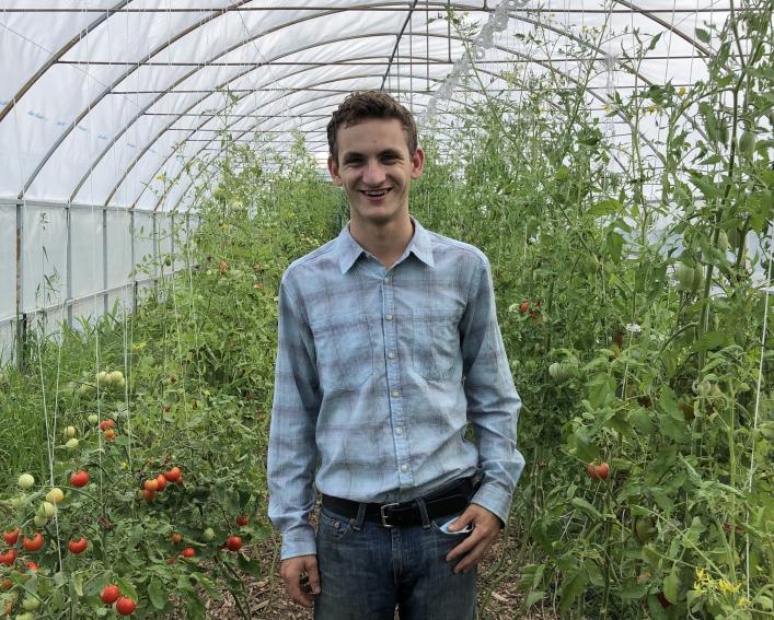 Eli standing in a greenhouse 