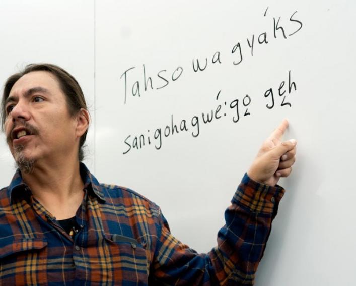 Steve Henhawk stands in front of a white board.