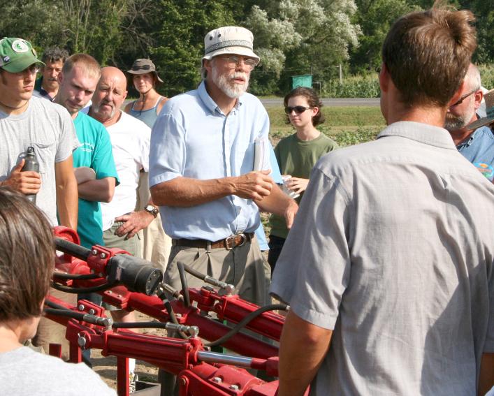 mohler explaining cultivation equipment to farmers at field day