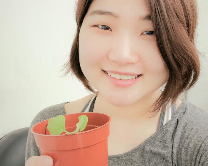 Female holds potted plant.